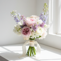 A charming petite bouquet of fresh seasonal blooms in soft complementary colors
